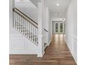 Bright hallway with hardwood flooring, white trim, wainscotting, and open access to other rooms at 741 Aristocrat Ln, Knightdale, NC 27545