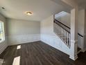 Bright living room features elegant trim, hardwood floors, and staircase with white banister at 741 Aristocrat Ln, Knightdale, NC 27545