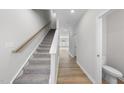 Bright hallway features carpeted stairs, hardwood floors and neutral paint tones at 84 Ripple Way # 313, Clayton, NC 27520