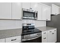 Close up on stainless steel oven, microwave and white subway tile backsplash at 84 Ripple Way # 313, Clayton, NC 27520