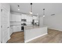 Open kitchen with white cabinets, granite countertops, stainless appliances and hardwood floors at 84 Ripple Way # 313, Clayton, NC 27520