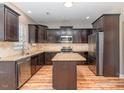 Spacious kitchen featuring stainless steel appliances, dark wood cabinetry, and granite countertops at 89 Bison Ln, Lillington, NC 27546