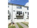 Back exterior of a modern townhouse with white siding, garages, and private balconies at 905 Myers Point Dr, Morrisville, NC 27560