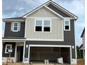 New two-story home with modern gray and white siding and an attached two-car garage at 97 Willow Cameron Way, Angier, NC 27501
