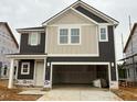 Two-story home featuring a two-car garage and a mix of vertical and horizontal siding at 97 Willow Cameron Way, Angier, NC 27501