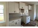 Bright kitchen features white cabinets, quartz countertops, herringbone backsplash and stainless steel hardware at 97 Willow Cameron Way, Angier, NC 27501