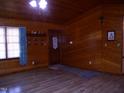 Inviting living room featuring wood-paneled walls and ample natural light at 105 Lake Rd, Henderson, NC 27537
