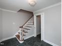 Elegant staircase featuring hardwood steps, white risers, and decorative chandelier, adjacent to a doorway at 1305 Glen Eden Dr, Raleigh, NC 27612