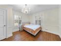 Cozy bedroom featuring a decorative chandelier and sun-filled windows with shutters at 1401 Granada Dr, Raleigh, NC 27612