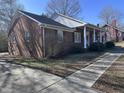 A charming brick home featuring a covered front porch with classic white columns and a walkway at 1926 W Front St, Burlington, NC 27215