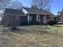 A well-maintained home with brick facade and a cozy front porch, set on a spacious lawn at 1926 W Front St, Burlington, NC 27215