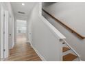 Clean and inviting hallway with hardwood floors and a staircase, creating a welcoming transition between spaces at 272 White Oak Garden Way # 209, Garner, NC 27529