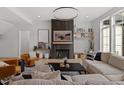 Bright living room featuring modern lighting, a fireplace, hardwood floors, and a comfortable seating arrangement at 299 Seaforth Landing Dr, Pittsboro, NC 27312