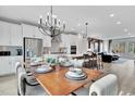 Open-concept dining and kitchen area with modern chandelier, adjacent to living room and kitchen island at 3024 Freewinds Way # 49, Cary, NC 27519