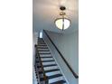 Staircase with wooden handrail and decorative light fixture at 322 Oak Branch Trl, Garner, NC 27529