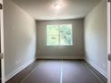 Cozy bedroom bathed in natural light from the window, complemented by light walls and dark wood floors at 362 Barbour Farm Ln, Four Oaks, NC 27524