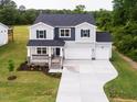 Two-story home showcasing well-manicured lawn, two-car garage, welcoming front porch, and stylish architectural details at 456 Barbour Farm Ln, Four Oaks, NC 27524