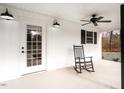 Close-up view of a covered porch with classic rocking chair next to white door at 4664 Quarter Creek Ln, Liberty, NC 27298