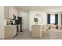 Modern kitchen featuring stainless steel appliances, sleek countertops, a center island, and an adjacent dining area at 47 Queenstown Dr, Kenly, NC 27542