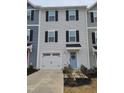 Charming townhome with a white garage door and a light blue front door, perfect for curb appeal at 5943 River Landings Dr, Raleigh, NC 27616