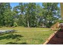 Large grassy backyard features mature trees, offering ample space for outdoor activities and relaxation at 610 Apple St, Gibsonville, NC 27249