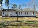 A single-story house featuring light siding and a small deck, facing the back yard at 610 Apple St, Gibsonville, NC 27249