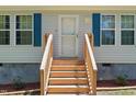 Inviting front entrance with freshly stained wooden steps, trimmed bushes, and house number above the door at 610 Apple St, Gibsonville, NC 27249