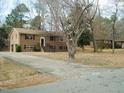 Traditional brick home featuring a symmetrical facade, long driveway and mature trees at 6112 Yellowstone Dr, Durham, NC 27713