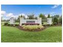 Inviting entrance to the neighborhood with manicured landscaping at 63 Lynn Crest Way, Four Oaks, NC 27524