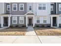 Inviting townhome entrance with stone accents, landscaped bushes, and a covered entryway at 6318 Perry Creek Rd, Raleigh, NC 27616