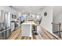 Bright, open kitchen with stainless appliances, island with bar seating, and hardwood floors at 6318 Perry Creek Rd, Raleigh, NC 27616
