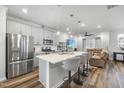 Modern kitchen with island, stainless steel appliances, pendant lighting, and open to living area at 6318 Perry Creek Rd, Raleigh, NC 27616