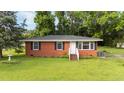 Charming brick home with a manicured front lawn, traditional curb appeal, and a welcoming front entrance at 702 Joyner St, Clayton, NC 27520