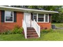 Charming brick home featuring a white front door with a brick step and painted white railing at 702 Joyner St, Clayton, NC 27520