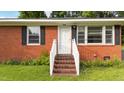 Inviting front entrance with brick steps, a white railing and a bright white front door at 702 Joyner St, Clayton, NC 27520
