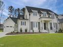Charming white brick house with black roof, shutters, and attached garage on a neatly landscaped lot at 7723 Roberts Rd, Apex, NC 27523