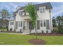 Two-story house with white brick exterior, black shutters, and a well-maintained lawn with fresh landscaping at 7723 Roberts Rd, Apex, NC 27523