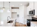 Bright kitchen featuring stainless steel appliances, white cabinetry, and stylish pendant lighting at 82 Little Crk Dr, Lillington, NC 27546