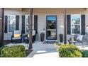 Inviting front porch with seating area, decorative plants, and a stylish front door at 103 Bella Sq Sq, Smithfield, NC 27577
