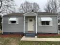Charming one-story home with light gray siding, awning-covered windows and a simple, inviting front entrance at 104 N Garden Ave, Siler City, NC 27344