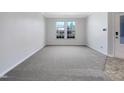 Spacious living area featuring neutral carpet and large windows for ample natural light at 1424 Elk Falls Dr, Wendell, NC 27591