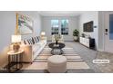Bright, staged living room with striped accents, modern furniture, and natural light at 1424 Elk Falls Dr, Wendell, NC 27591