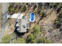 Aerial view of the property showcasing a pool and expansive lot surrounded by trees in a residential neighborhood at 198 Gentry Dr, Pittsboro, NC 27312