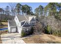Rear view of the two-story home with a two-car garage, showcasing its backyard and natural surroundings at 198 Gentry Dr, Pittsboro, NC 27312