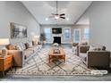 Bright, staged living room featuring a vaulted ceiling, recessed lighting, fireplace, ceiling fan, and hardwood flooring at 201 Silver Creek Dr, Clayton, NC 27520