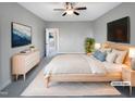 This staged bedroom features a ceiling fan, television, light wood furniture, and a light-colored rug at 201 Silver Creek Dr, Clayton, NC 27520