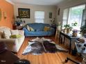 Cozy living room featuring hardwood floors, natural light from the windows, and comfortable furnishings at 2201 Valiant St, Raleigh, NC 27610