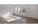 Bright living room with wood floors and abundant natural light from large windows at 260 Chesapeake Commons St # 156, Garner, NC 27529