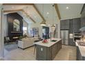 Open-concept living room with a fireplace, exposed beams, chandelier, and seamless flow to the kitchen at 306 Golden Leaf Farms Rd, Angier, NC 27501
