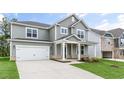 Two-story home with gray siding, white trim, a covered front porch, and an attached two-car garage at 309 Umstead St, Sanford, NC 27330